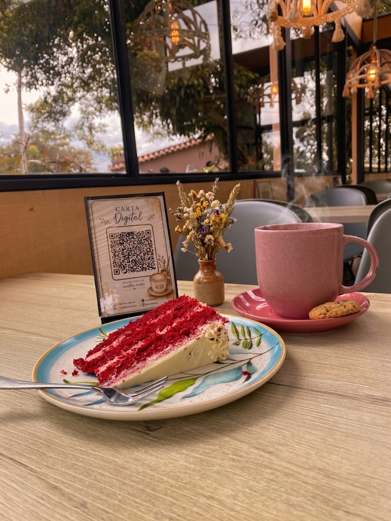 Torta red velvet y café servidos en una mesa del local, con la Carta Digital junto a la ventana